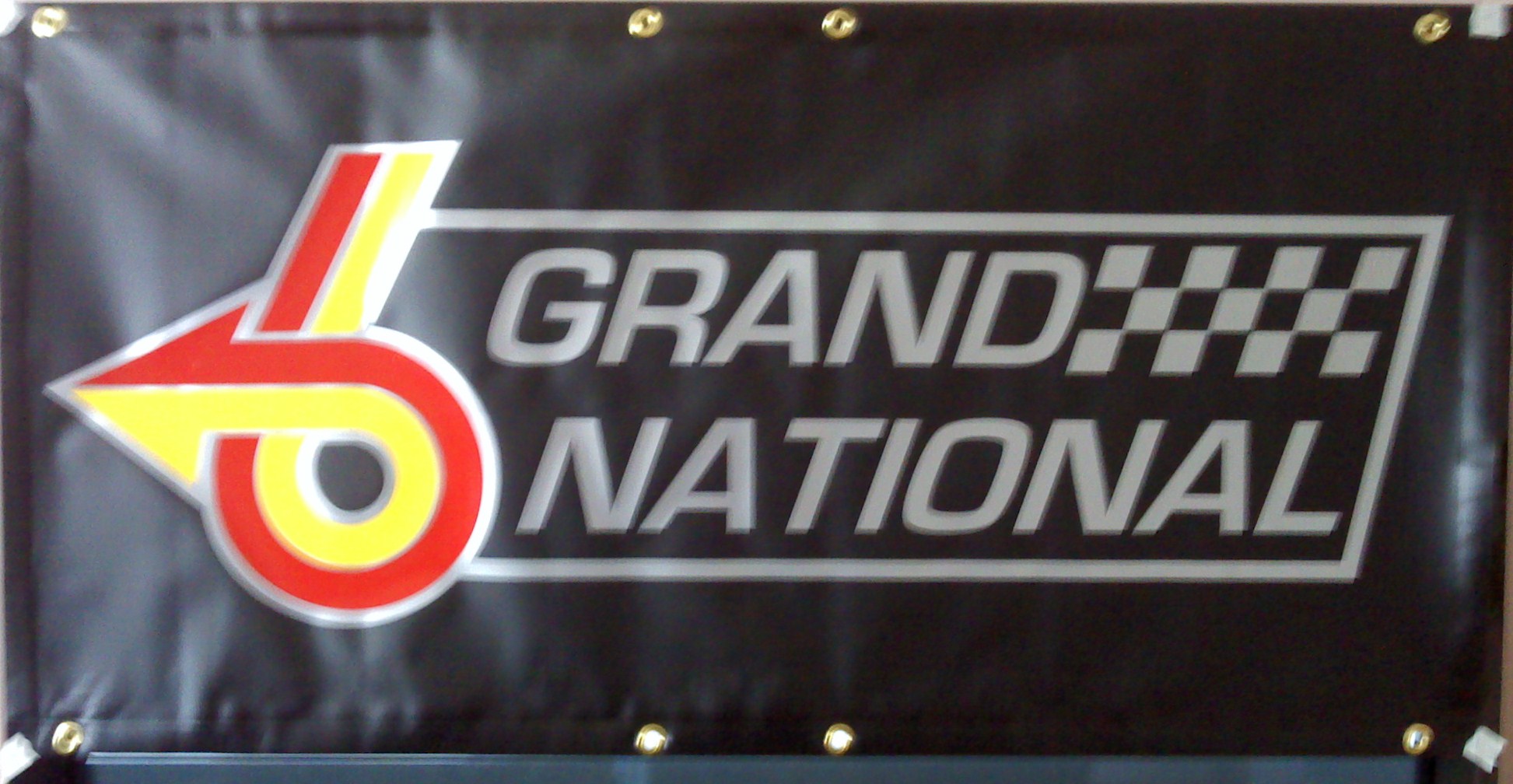 Grand National premium 13 oz vinyl banner, black with red, yellow and silver lettering 2 FT x 4 FT